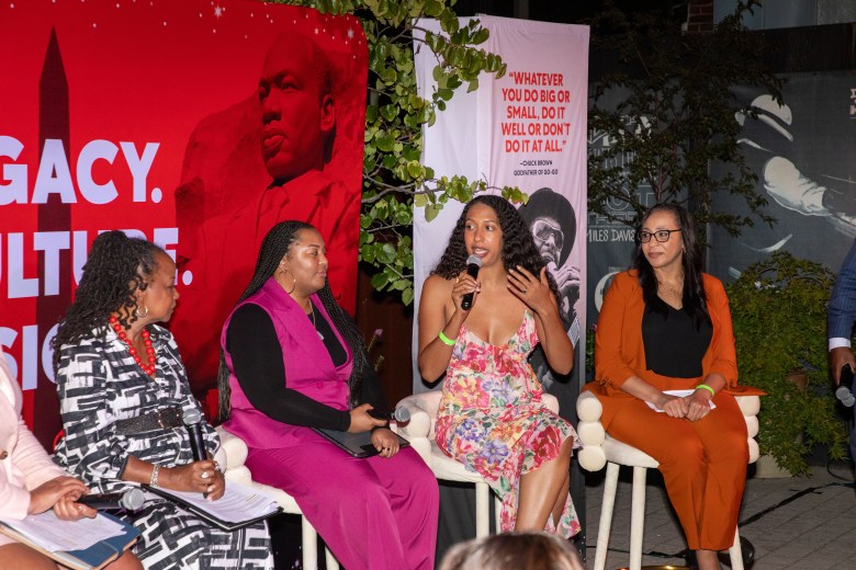Elizabeth Booker Houston, known as Booker Squared, speaking on stage at the Washington Informer Visual Legacy Exhibit forum.