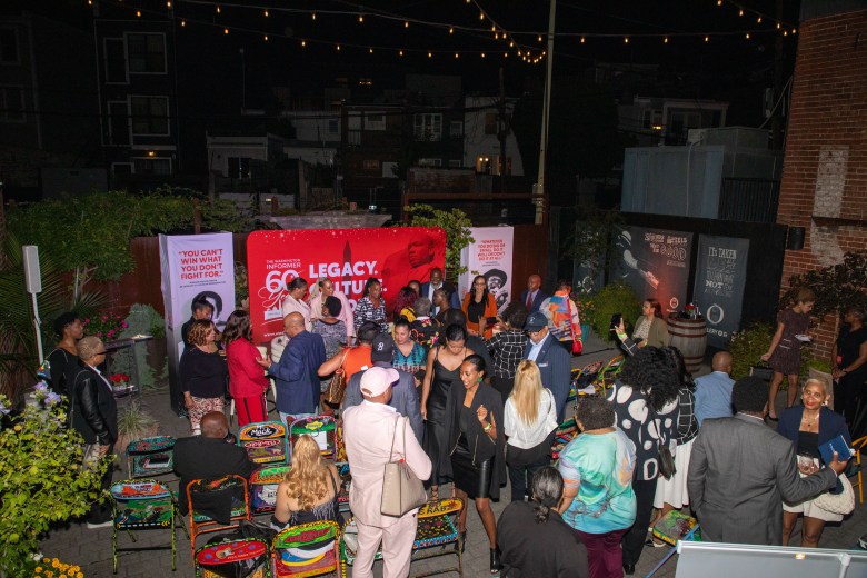 Audience seated outdoors listening to panel at the Washington Informer Visual Legacy Exhibit forum.