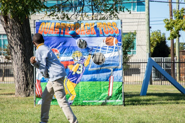Student participates in the quarterback toss station at the #SteamtheBlock Party.