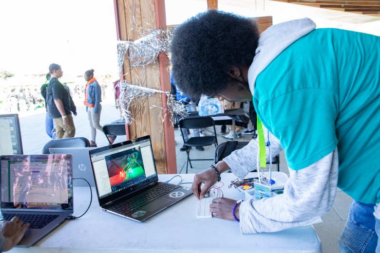 A student works on a circuit board at the technology station during the #STEAMtheBlock Party in Washington, D.C.