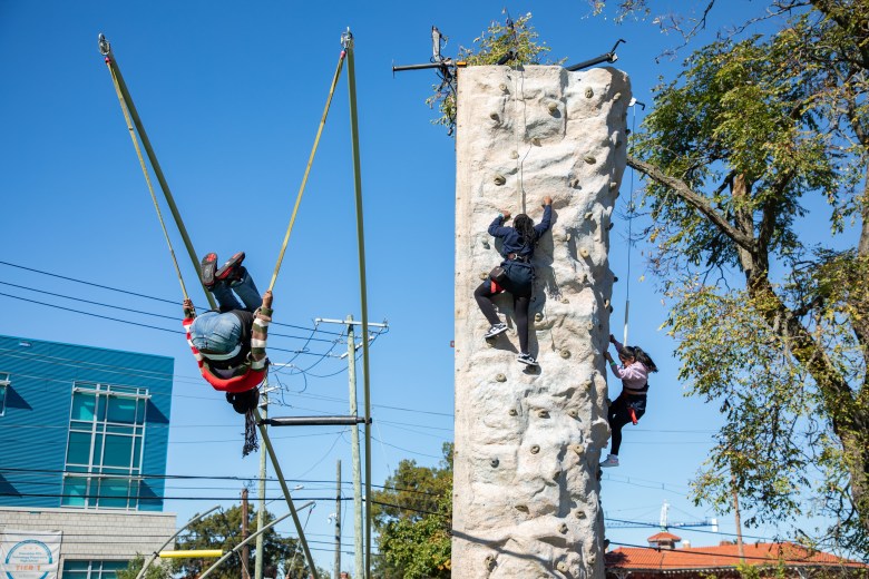 Student does a backflip on a bungee trampoline at the #SteamtheBlock Party.