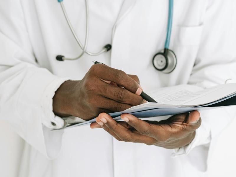 person holding pen writing on paper